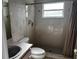 Bathroom with tiled shower, toilet, and sink with wallpapered walls at 1039 Greenturf Rd, Spring Hill, FL 34608