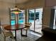 Bright dining area with a view of the screened-in pool, creating a relaxed atmosphere at 1039 Greenturf Rd, Spring Hill, FL 34608