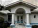 Home featuring a white exterior with arched entryway, columns, and double doors with oval windows at 1039 Greenturf Rd, Spring Hill, FL 34608