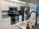 Well-equipped kitchen with stainless steel appliances, white cabinets, and updated fixtures at 1039 Greenturf Rd, Spring Hill, FL 34608