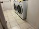 Bright laundry room features a side-by-side washer and dryer and tile floors at 1039 Greenturf Rd, Spring Hill, FL 34608