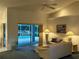 Living room with ceiling fan, painting and sliding doors leading to a screened outdoor pool at 1039 Greenturf Rd, Spring Hill, FL 34608