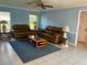 Comfortable living room featuring leather couches, neutral colored tile floor and walls, and a ceiling fan at 1039 Greenturf Rd, Spring Hill, FL 34608