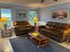 Comfortable living room featuring leather couches, neutral colored tile floor and walls, and a ceiling fan at 1039 Greenturf Rd, Spring Hill, FL 34608