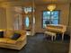 Living room featuring a sofa, piano, chandelier, and view into the front entrance at 1039 Greenturf Rd, Spring Hill, FL 34608