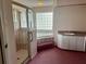 Main bath with a walk-in shower, tub, sink, and a large window at 1039 Greenturf Rd, Spring Hill, FL 34608