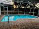 Outdoor pool with brick paver deck and screen enclosure with a view of the backyard at 1039 Greenturf Rd, Spring Hill, FL 34608
