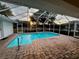 Outdoor pool with brick paver deck and screen enclosure, providing a beautiful view of the yard at 1039 Greenturf Rd, Spring Hill, FL 34608