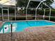 A refreshing screened-in pool with a brick paved patio, with sunset view over landscaped backyard at 1039 Greenturf Rd, Spring Hill, FL 34608
