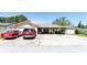Single-story home with two cars parked in the driveway, front porch, and well-maintained landscaping at 11996 117Th St, Seminole, FL 33778