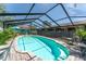 An enclosed pool area featuring a screened enclosure, brick pavers, and outdoor seating for relaxation at 11996 117Th St, Seminole, FL 33778
