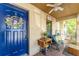 Inviting porch with a blue front door, decorative wreath, and cozy bench, creating a welcoming outdoor space at 11996 117Th St, Seminole, FL 33778