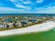 Aerial view of the building, beachfront, and intracoastal waterway with beautiful white sands and clear green ocean water at 12000 Gulf Blvd # 506N, Treasure Island, FL 33706