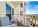 Private balcony with seating overlooking a stunning ocean and a pool at 12000 Gulf Blvd # 506N, Treasure Island, FL 33706