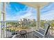 Relax on the balcony with seating and views of the beach, trees, and blue sky at 12000 Gulf Blvd # 506N, Treasure Island, FL 33706