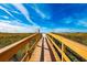 Wooden boardwalk leads to a white sandy beach under a bright blue sky at 12000 Gulf Blvd # 506N, Treasure Island, FL 33706