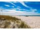 Sandy beach with ocean views under a bright blue sky with few people at 12000 Gulf Blvd # 506N, Treasure Island, FL 33706
