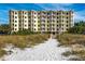 Sandy path to the exterior of the building with balconies at 12000 Gulf Blvd # 506N, Treasure Island, FL 33706