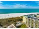 Exterior view of multi-level building situated directly on a white sandy beach with gorgeous views of the ocean at 12000 Gulf Blvd # 506N, Treasure Island, FL 33706