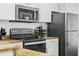 Modern kitchen featuring white cabinets, granite countertops, and stainless-steel appliances at 12000 Gulf Blvd # 506N, Treasure Island, FL 33706