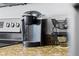 Close up of the kitchen counter with coffee maker, tan granite, and stainless-steel appliances at 12000 Gulf Blvd # 506N, Treasure Island, FL 33706