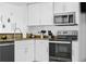 Modern kitchen featuring white cabinets, granite countertops, and stainless-steel appliances at 12000 Gulf Blvd # 506N, Treasure Island, FL 33706
