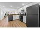 Bright kitchen featuring white cabinets, granite countertops, and sleek black appliances opens to the living area at 12000 Gulf Blvd # 506N, Treasure Island, FL 33706