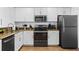 Modern kitchen featuring white cabinets, granite countertops, and sleek black appliances for a contemporary aesthetic at 12000 Gulf Blvd # 506N, Treasure Island, FL 33706