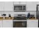 Close-up of a kitchen with white cabinets, granite countertops, and stainless steel appliances at 12000 Gulf Blvd # 506N, Treasure Island, FL 33706