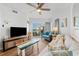 Bright living room showcases a ceiling fan, balcony view, and beach-themed decor for relaxation at 12000 Gulf Blvd # 506N, Treasure Island, FL 33706