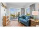 Bright living room with a balcony and ocean view features a blue couch and beachy decor at 12000 Gulf Blvd # 506N, Treasure Island, FL 33706