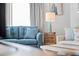 Comfortable living room features a blue couch, rustic side table with lamp, and serene coastal decor at 12000 Gulf Blvd # 506N, Treasure Island, FL 33706