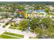 Bird's-eye view of neighborhood with lush trees and a pond, arrow points to home with screened-in pool at 12092 97Th Ave, Seminole, FL 33772