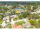 Aerial view of a neighborhood featuring mature trees and a nearby pond, with an arrow pointing to subject property at 12092 97Th Ave, Seminole, FL 33772