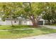 Single-story home featuring a big tree, manicured lawn, freshly painted, and a decorative glass front door at 12092 97Th Ave, Seminole, FL 33772
