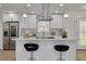 Modern kitchen featuring stainless steel appliances, white cabinetry, and a quartz countertop island with stylish bar stools at 12092 97Th Ave, Seminole, FL 33772