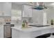 Bright kitchen showcasing white cabinets, stainless steel appliances, quartz counters, and a stylish vent hood at 12092 97Th Ave, Seminole, FL 33772