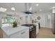 Spacious kitchen island with cooktop, stainless oven, quartz countertops and modern lighting at 12092 97Th Ave, Seminole, FL 33772