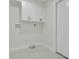 Clean laundry room with white cabinets, white tile floors, and a utility sink at 12092 97Th Ave, Seminole, FL 33772