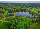 Aerial view of a tranquil pond with walking paths and lush greenery at 1242 Whisper Dr, Largo, FL 33770