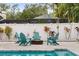 Backyard with fire pit, Adirondack chairs and string lights providing a cozy outdoor space at 1242 Whisper Dr, Largo, FL 33770