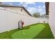 Backyard putting green, white fence, string lights, artificial turf and room to enjoy the outdoors at 1242 Whisper Dr, Largo, FL 33770