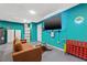 Finished basement with a brown sofa, turquoise walls, and a large wall-mounted television at 1242 Whisper Dr, Largo, FL 33770