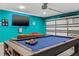 Finished basement with a pool table, television, and a brown leather sofa at 1242 Whisper Dr, Largo, FL 33770