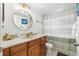 Stylish bathroom with a round mirror, and a shower with a striped curtain at 1242 Whisper Dr, Largo, FL 33770