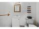 Bathroom with a vanity, mirror, toilet, towel bar, and decorative beach-themed wall art at 1242 Whisper Dr, Largo, FL 33770