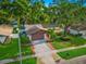 Well-maintained single-Gathering home featuring a lush, landscaped front yard and a two-car garage at 1242 Whisper Dr, Largo, FL 33770