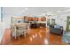 Open-concept living room featuring wood floors, kitchen with island, and dining area, perfect for entertaining at 1242 Whisper Dr, Largo, FL 33770