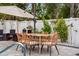 Outdoor patio featuring dining table, chairs, and white fence with ambient lighting at 1242 Whisper Dr, Largo, FL 33770