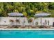 Beautiful poolside view with lounge chairs and umbrellas, creating a relaxing outdoor oasis at 1242 Whisper Dr, Largo, FL 33770